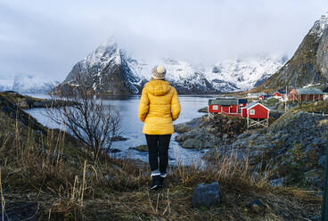 Tourist genießt die Aussicht in Hamnoy, Lofoten, Norwegen - DGOF00101