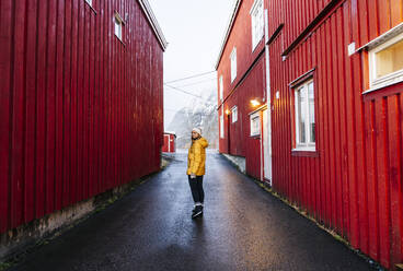 Tourist exploring the fishing village Hamnoy, Lofoten, Norway - DGOF00104