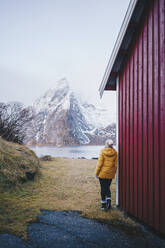 Tourist genießt die Aussicht in Hamnoy, Lofoten, Norwegen - DGOF00105