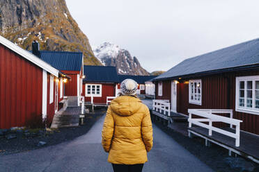 Tourist bei der Erkundung des Fischerdorfs Hamnoy, Lofoten, Norwegen - DGOF00108