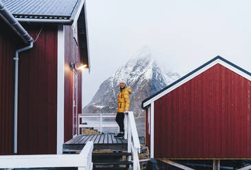 Tourist auf einer Veranda in Hamnoy, Lofoten, Norwegen - DGOF00110