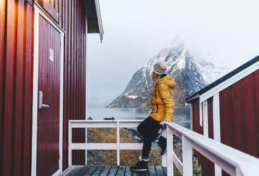 Tourist auf einer Veranda in Hamnoy, Lofoten, Norwegen - DGOF00111