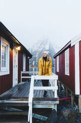 Tourist auf einer Veranda in Hamnoy, Lofoten, Norwegen - DGOF00115