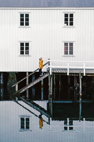 Tourist auf einem Steg am Wasser in Hamnoy, Lofoten, Norwegen, lizenzfreies Stockfoto