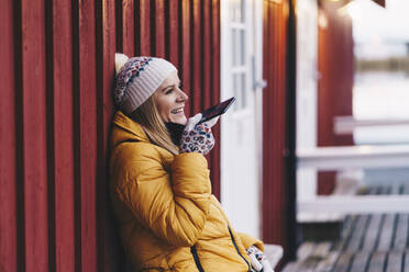 Glücklicher Tourist mit Smartphone in Hamnoy, Lofoten, Norwegen - DGOF00129