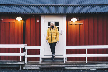 Tourist leaving a hut at Hamnoy, Lofoten, Norway - DGOF00130