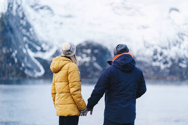 Tourist couple enjoying the view at Hamnoy, Lofoten, Norway - DGOF00140