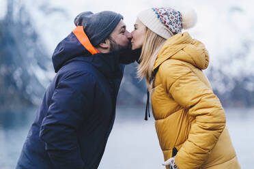 Tourist couple kissing at Hamnoy, Lofoten, Norway - DGOF00143