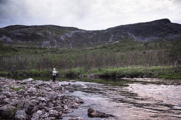 Fly fisherman fishing for salmons in river, Lakselv, Norway - DHEF00071