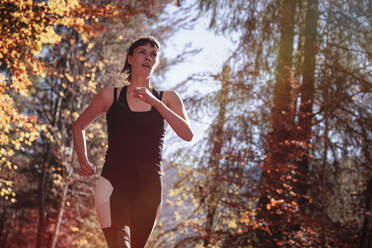 Frau joggt im Herbstwald - DHEF00085