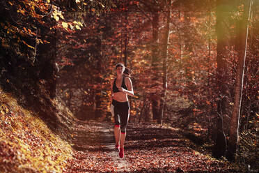 Frau joggt im Herbstwald - DHEF00086