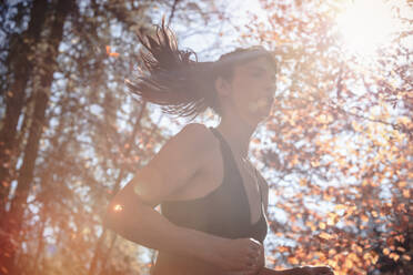 Woman jogging in autumn forest - DHEF00088