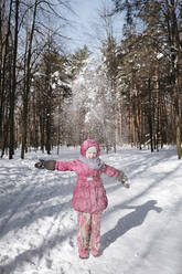 Little girl throwing snow in winter forest - EYAF00907