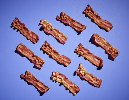 Studio shot of bacon strips against purple background - KSWF02128