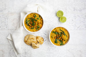 Veganes Linsencurry mit roten Linsen, Süßkartoffeln, Spinat, gerösteter Kurkuma, Kichererbsen, mit Limettensaft und Koriander und Naan-Brot - LVF08575