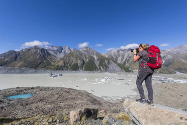 Neuseeland, Ozeanien, Südinsel, Canterbury, Ben Ohau, Südliche Alpen (Neuseeländische Alpen), Mount Cook National Park, Tasman Glacier Viewpoint, Frau fotografiert Tasman Lake mit Eisschollen - FOF11625