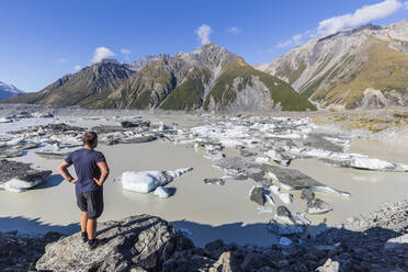 New Zealand, Oceania, South Island, Canterbury, Ben Ohau, Southern Alps (New Zealand Alps), Mount Cook National Park, Man standing by Tasman Lake with ice floes - FOF11634