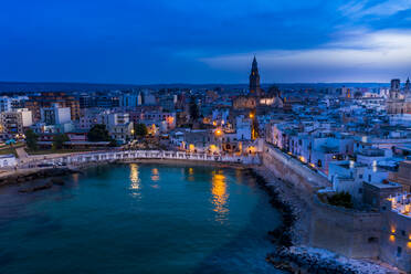 Italy, Apulia, Monopoli, Aerial view of sea and old town at sunset - AMF07789