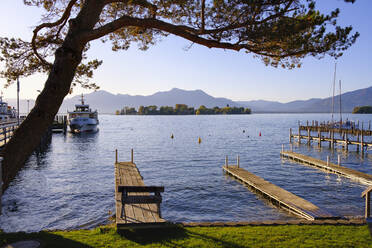 Deutschland, Bayern, Gstadt am Chiemsee, Bootsstege am Ufer des Chiemsees mit Fraueninsel im Hintergrund - SIEF09451