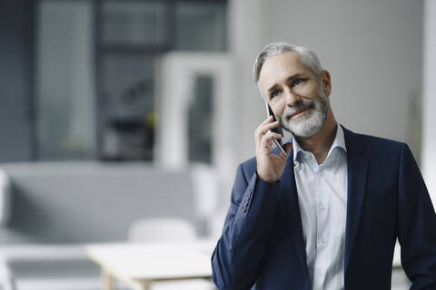 Porträt eines lächelnden reifen Geschäftsmannes am Telefon, lizenzfreies Stockfoto