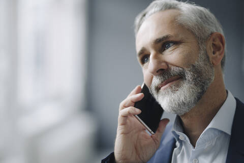 Portrait of smiling mature businessman on the phone stock photo