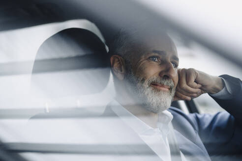 Porträt eines lächelnden reifen Geschäftsmannes in seinem Auto - KNSF07371