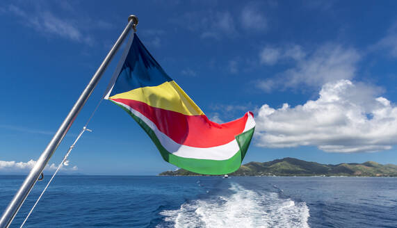 Seychelles, Praslin Island, Flag of Seychelles and sea - MABF00548