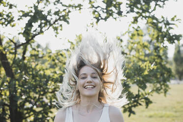 Porträt einer blonden jungen Frau mit wehendem Haar im Sommer - BFRF02181