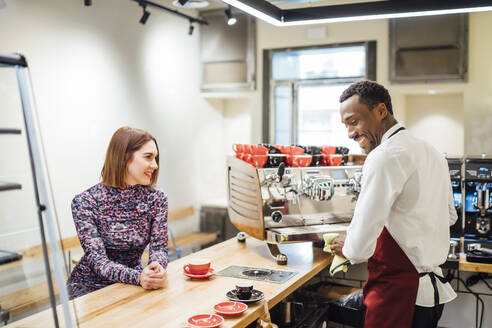 Woman at the counter in a cafe placing the order - OCMF01023