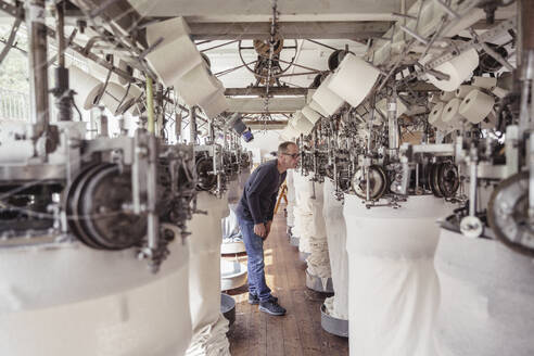 Mann arbeitet an einer Maschine in einer Textilfabrik - SDAHF00057