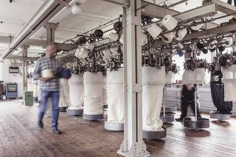 Blurred view of man walking in a textile factory stock photo