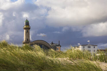 Deutschland, Mecklenburg-Vorpommern, Warnemünde, Gras auf Sanddünen und Leuchtturm - WDF05730