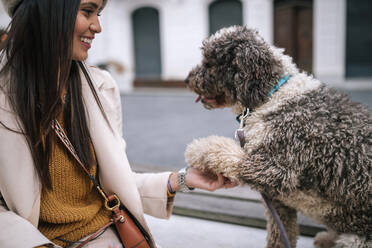 Young woman with her dog in the city giving paw - GRCF00140