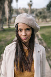 Portrait of young woman with beret in a park - GRCF00142