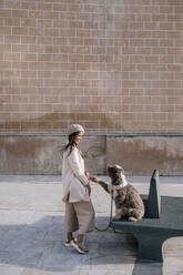 Young woman with her dog in the city giving paw - GRCF00150