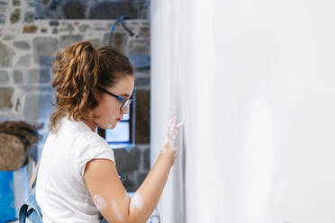 Mädchen malt mit dem Finger auf eine Wand - DGOF00223