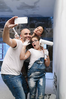 Glückliche Familie macht ein Selfie beim Streichen der Wände ihres neuen Hauses - DGOF00241