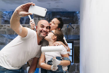 Glückliche Familie macht ein Selfie beim Streichen der Wände ihres neuen Hauses - DGOF00242