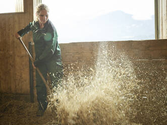 Bäuerin bei der Arbeit mit Stroh auf einem Bauernhof - CVF01563