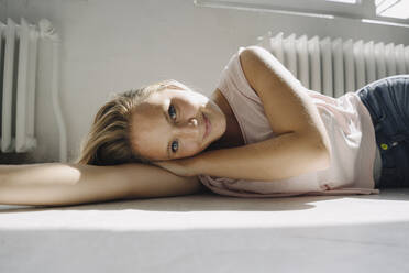 Portrait of blond young woman lying on the floor - KNSF07381