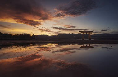 Japan, Hiroshima, Miyajima, floating gate of Itsukushima Shrine at sunset - DVGF00082