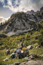 Frau mit Hund auf Wandertour am Wilden Kaiser beim Pausieren, Kaisergebirge, Tirol, Österreich - MSUF00173