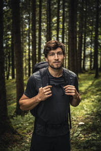 Porträt eines Mannes mit Rucksack bei einer Wanderung im Wald, Karwendel, Tirol, Österreich - MSUF00187