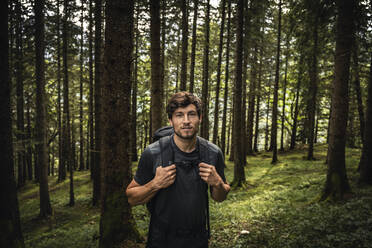 Portrait of a man with backpack on a hiking trip in forest, Karwendel, Tyrol, Austria - MSUF00188