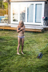 Girl in garden with water sprinkler - JOHF06282