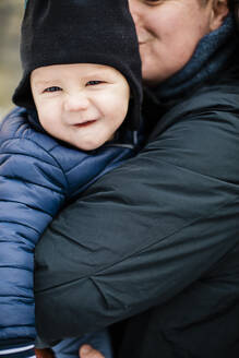 Lächelnder Junge in den Armen seines Vaters - JOHF06324