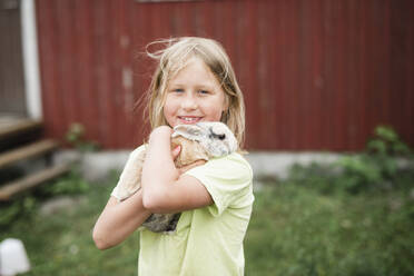 Mädchen hält Kaninchen - JOHF06440