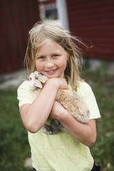 Mädchen hält Kaninchen - JOHF06441