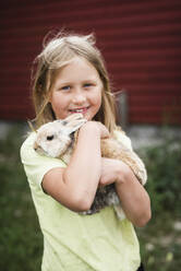 Mädchen hält Kaninchen - JOHF06442