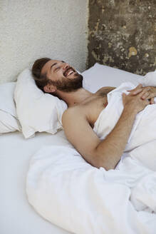 Smiling man in bed - JOHF06479